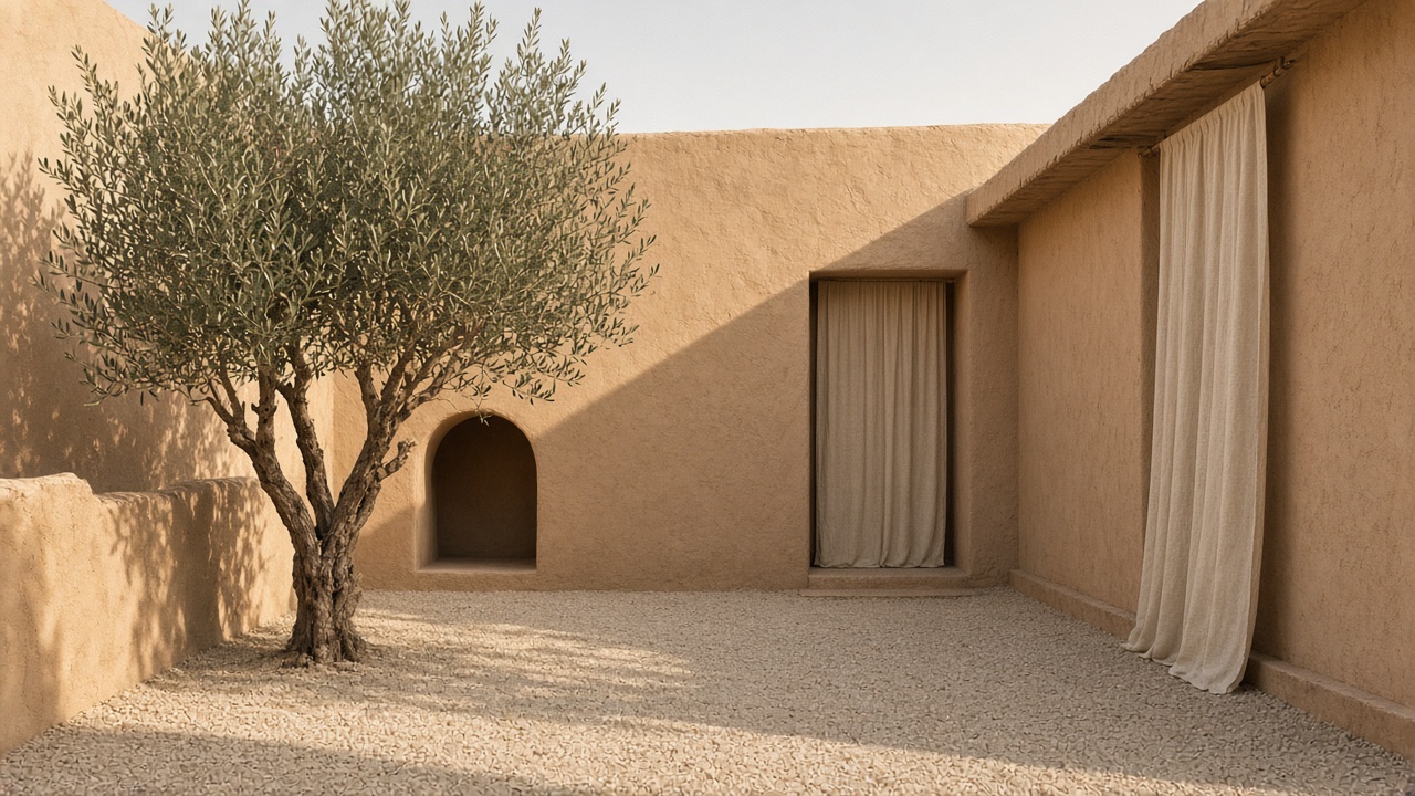 An empty sand courtyard with one olive tree, plaster walls, and a linen curtain.